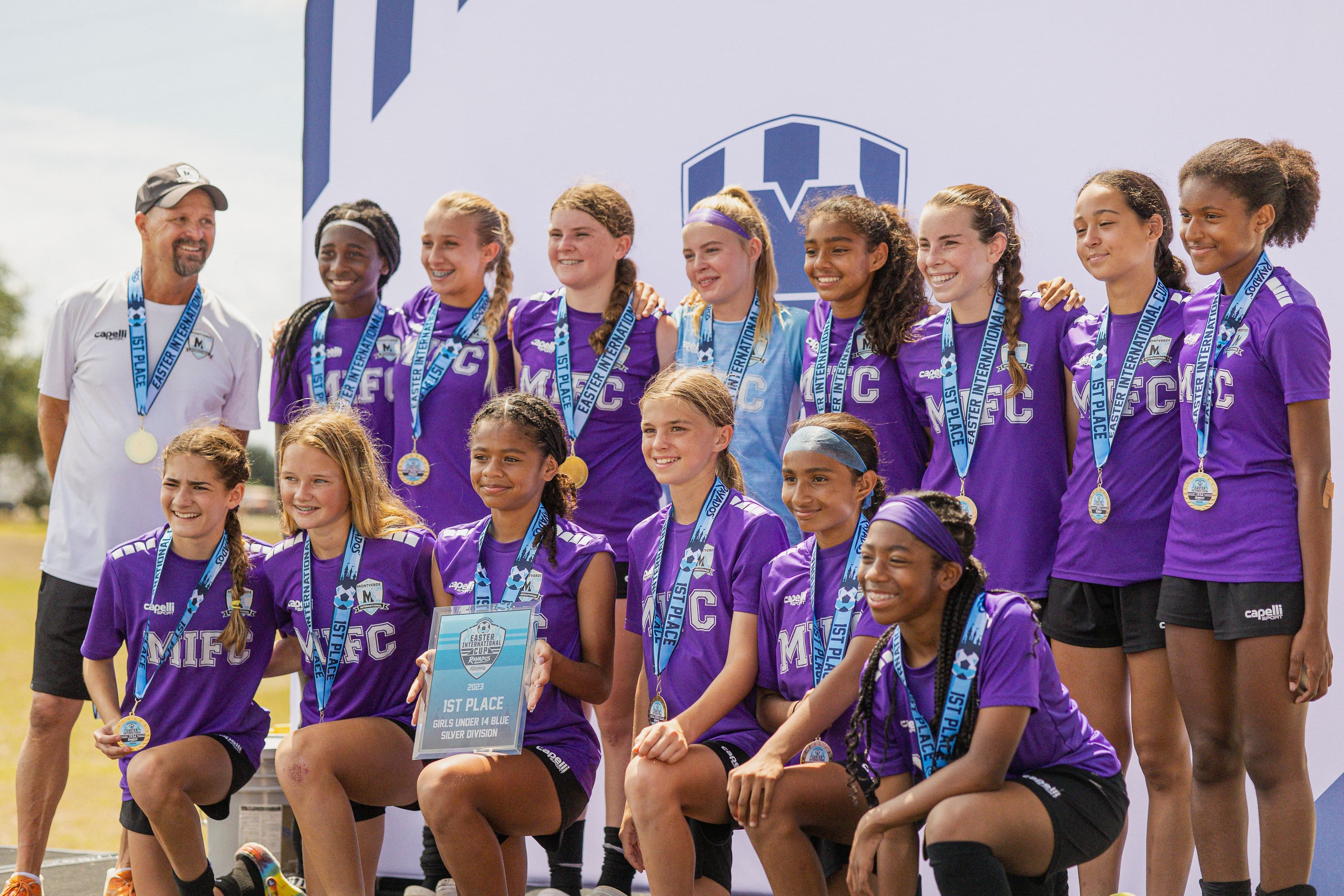 A girls team with their medals and first-place award at Easter International Cup in 2023