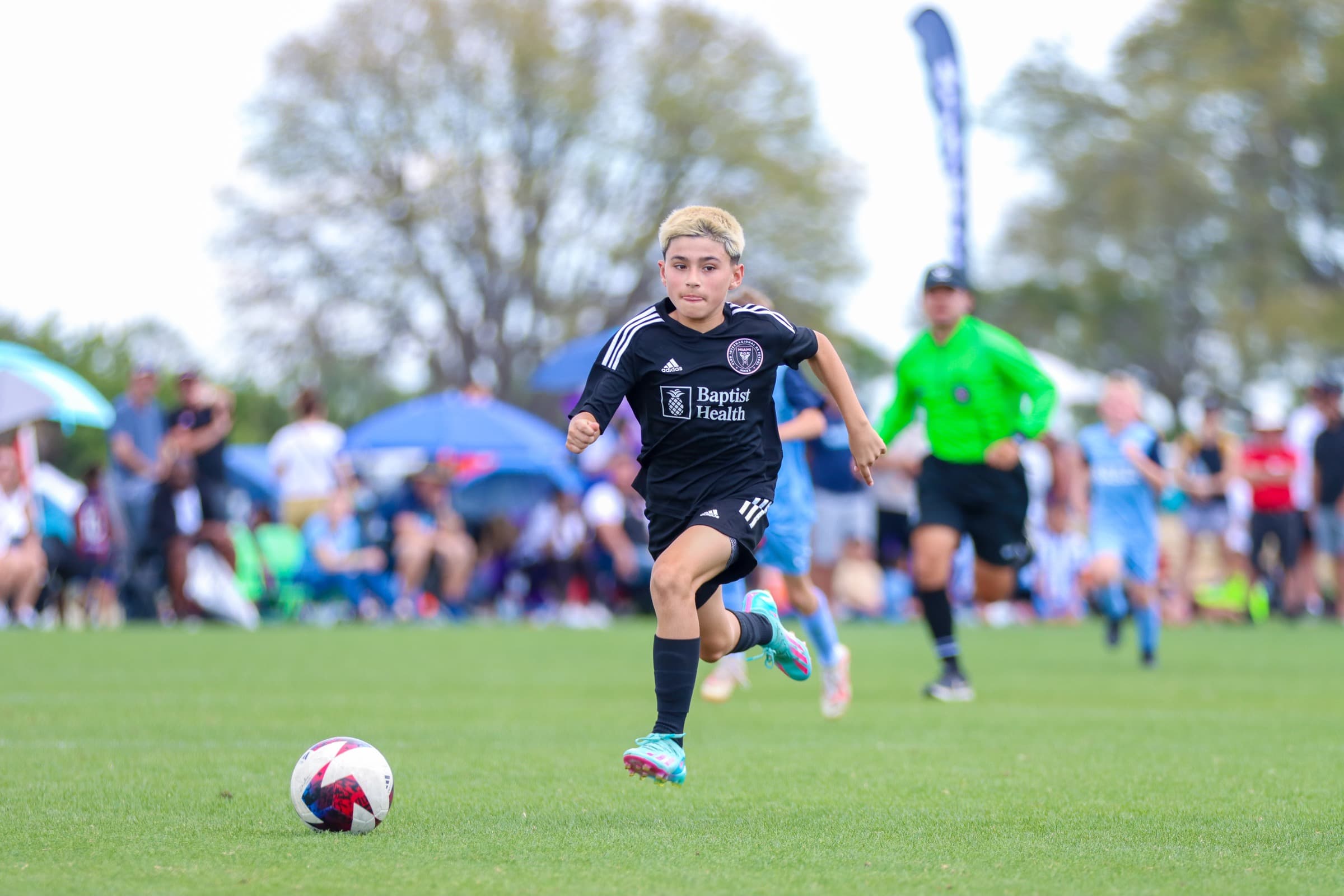 A youth soccer player carrying the ball during tournament play