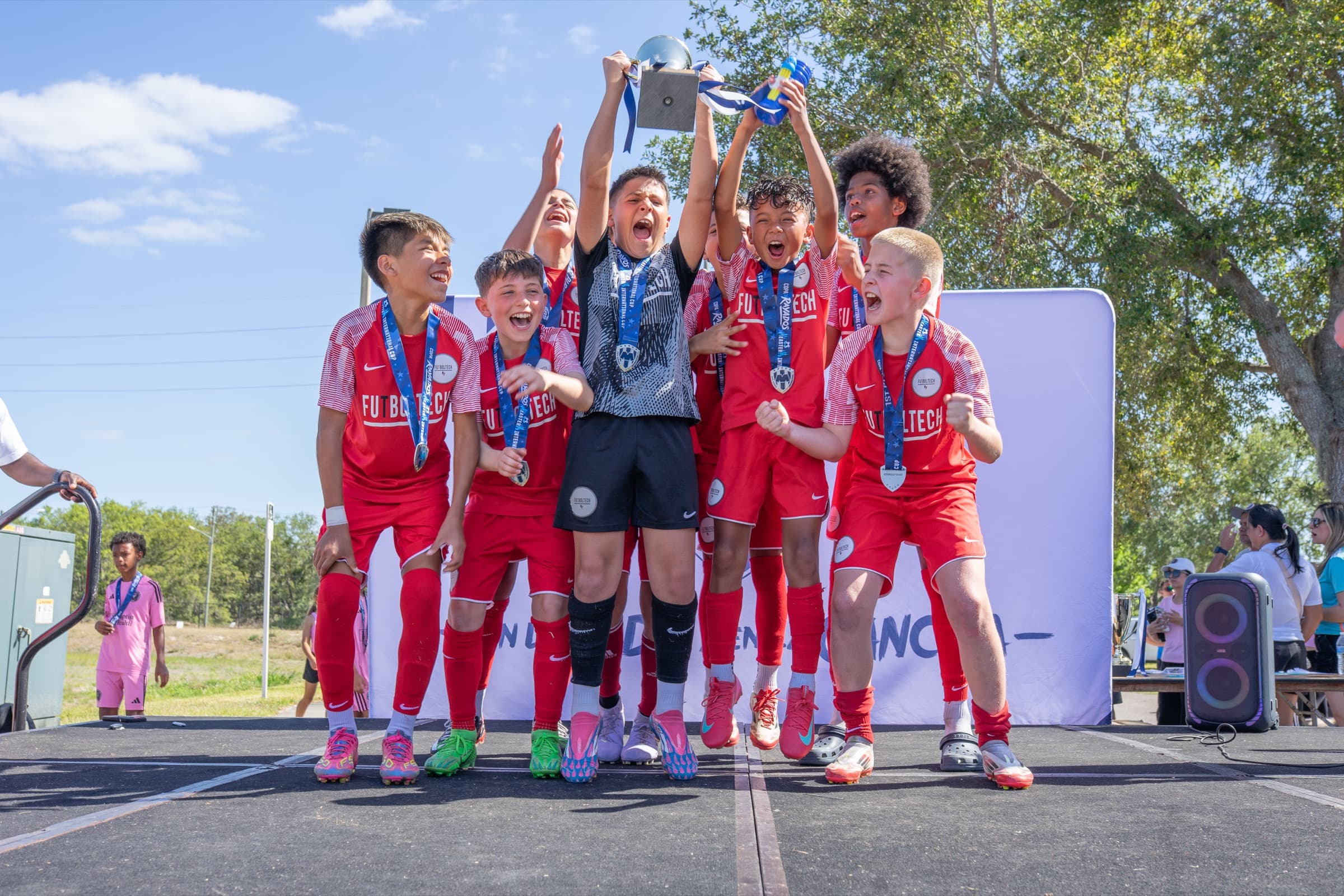 Youth soccer players celebrating together with their tournament trophy